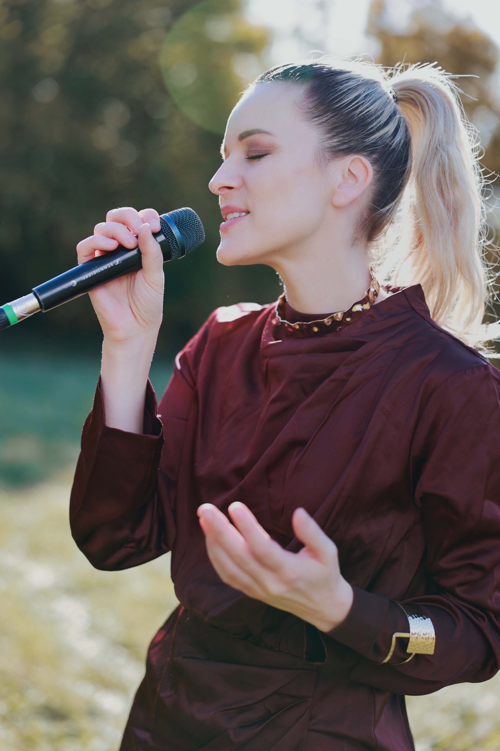 Sängerin Kathalena für Hochzeiten und Taufen mit Mikrofon im Grünen