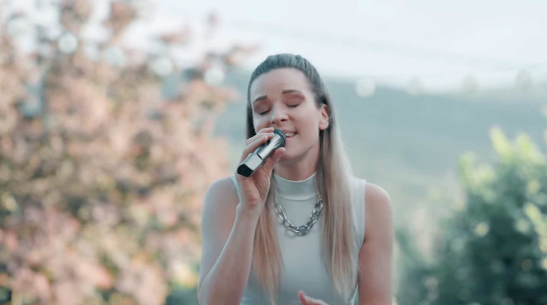 Kathalena - Sängerin für Taufen singt draußen Bäume im Hintergrund